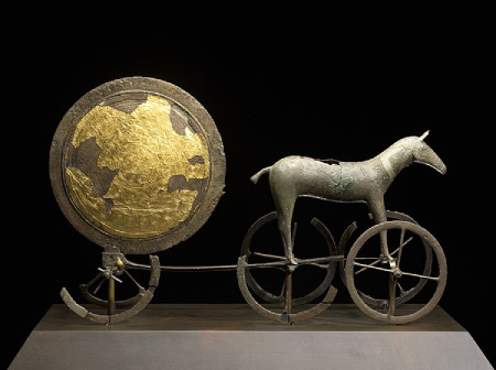 A bronze figure of a stylised horse, pulling a chariot in which a gold plated disc sits, believed to represent the sun